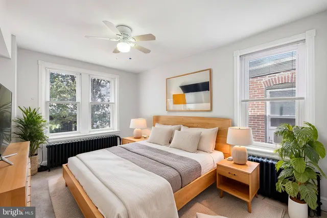 a bedroom with a bed table closet and a window