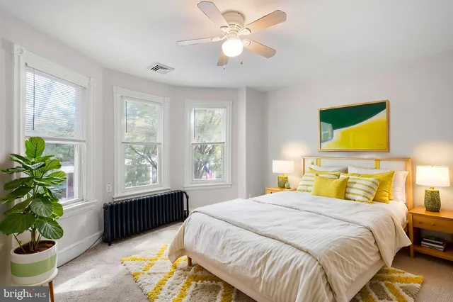 a bedroom with a bed potted plant with the outer view