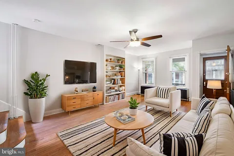 a living room with furniture a flat screen tv and a potted plant
