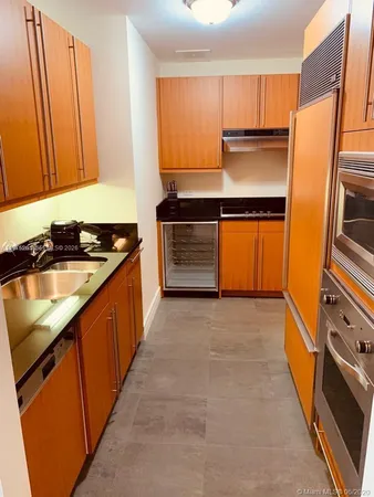 a kitchen with stainless steel appliances kitchen island a refrigerator sink and stove
