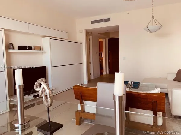 a living room with furniture a flat screen tv and a table