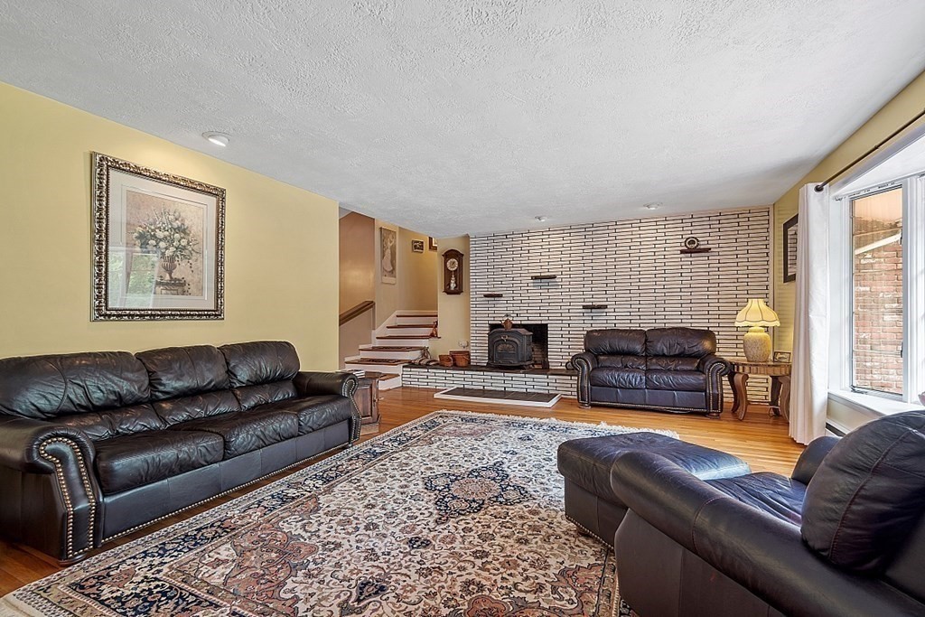 12 Sheridan Road Andover, MA 01810 - Photo 17 of 40 a living room with furniture a fireplace and a large window