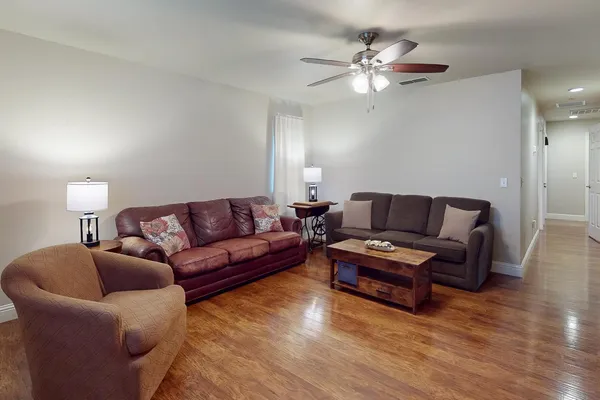 a living room with furniture and a ceiling fan