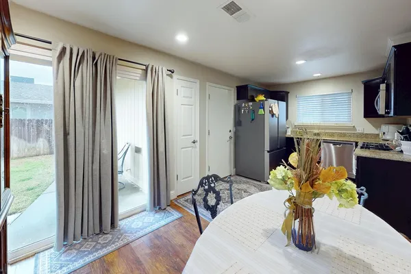 a living room with stainless steel appliances furniture a chandelier and a view of kitchen