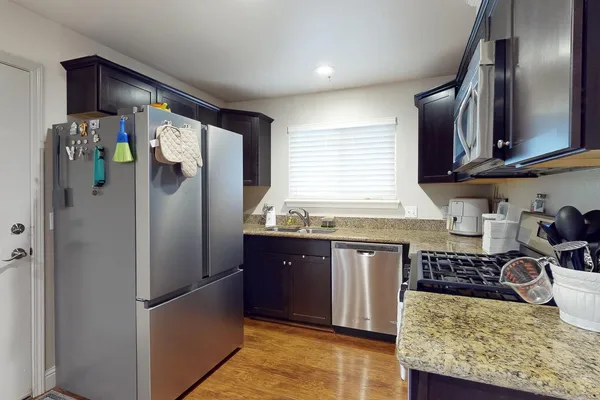 a kitchen with stainless steel appliances granite countertop a refrigerator and a sink