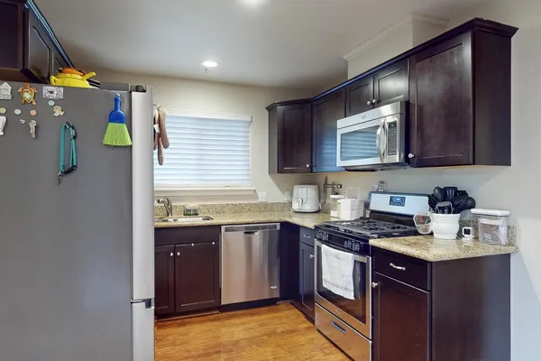 a kitchen with stainless steel appliances granite countertop a sink stove and cabinets
