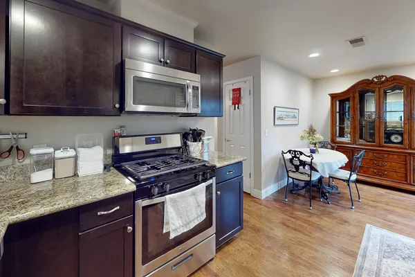 a kitchen with stainless steel appliances granite countertop a stove a sink and a microwave