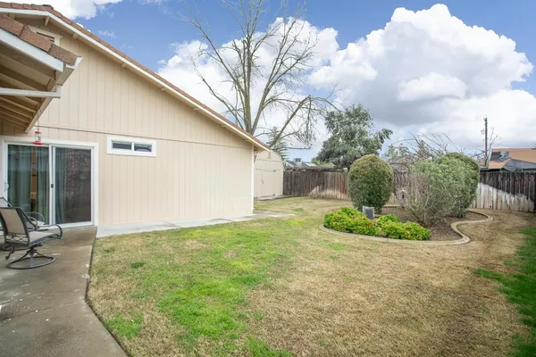 a backyard of a house with table and chairs
