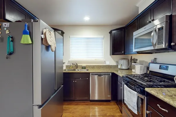 a kitchen with stainless steel appliances granite countertop a stove a sink and a microwave