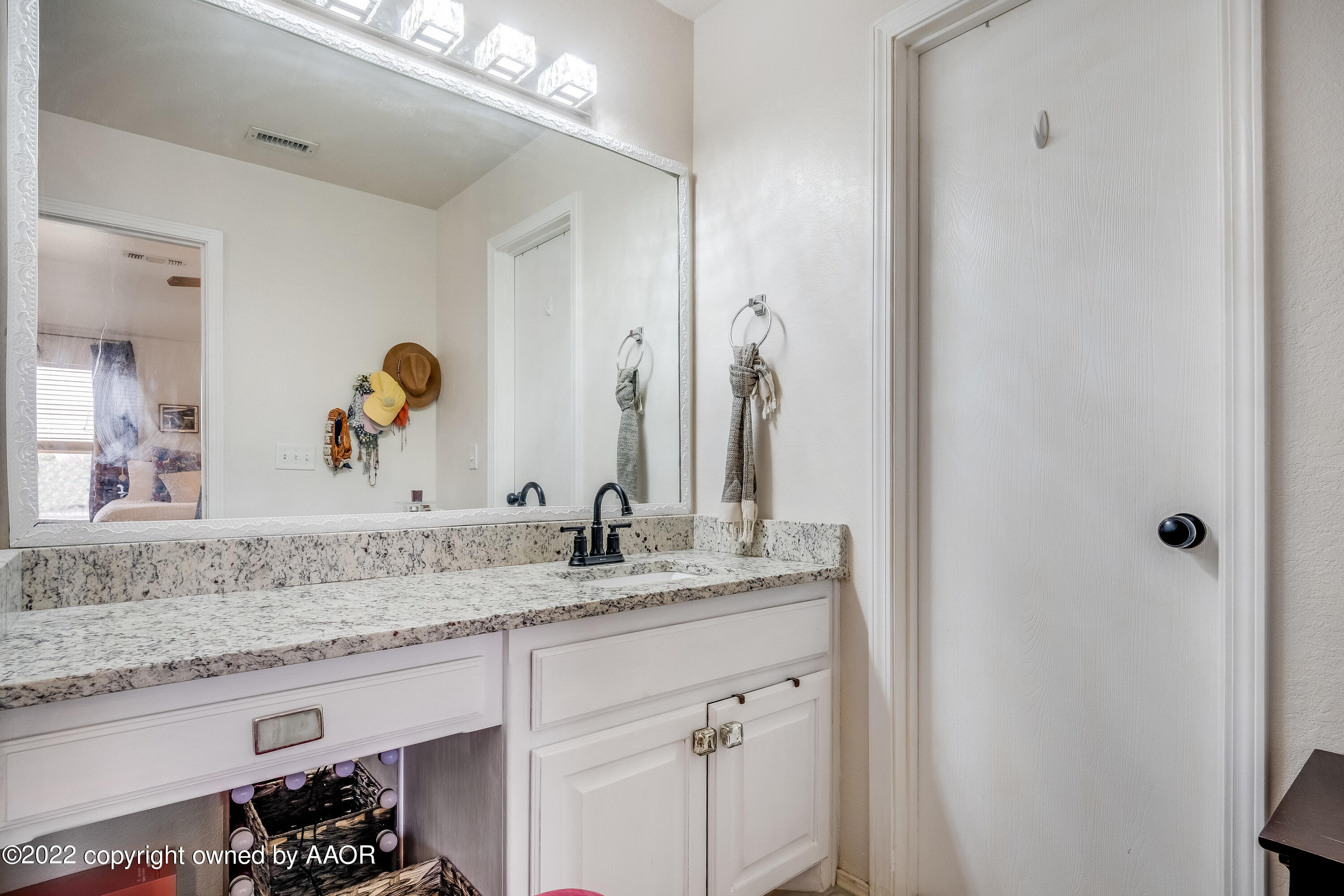 5001 Capulin Lane Amarillo, TX 79110 - Photo 14 of 22 a bathroom with a granite countertop sink and a mirror