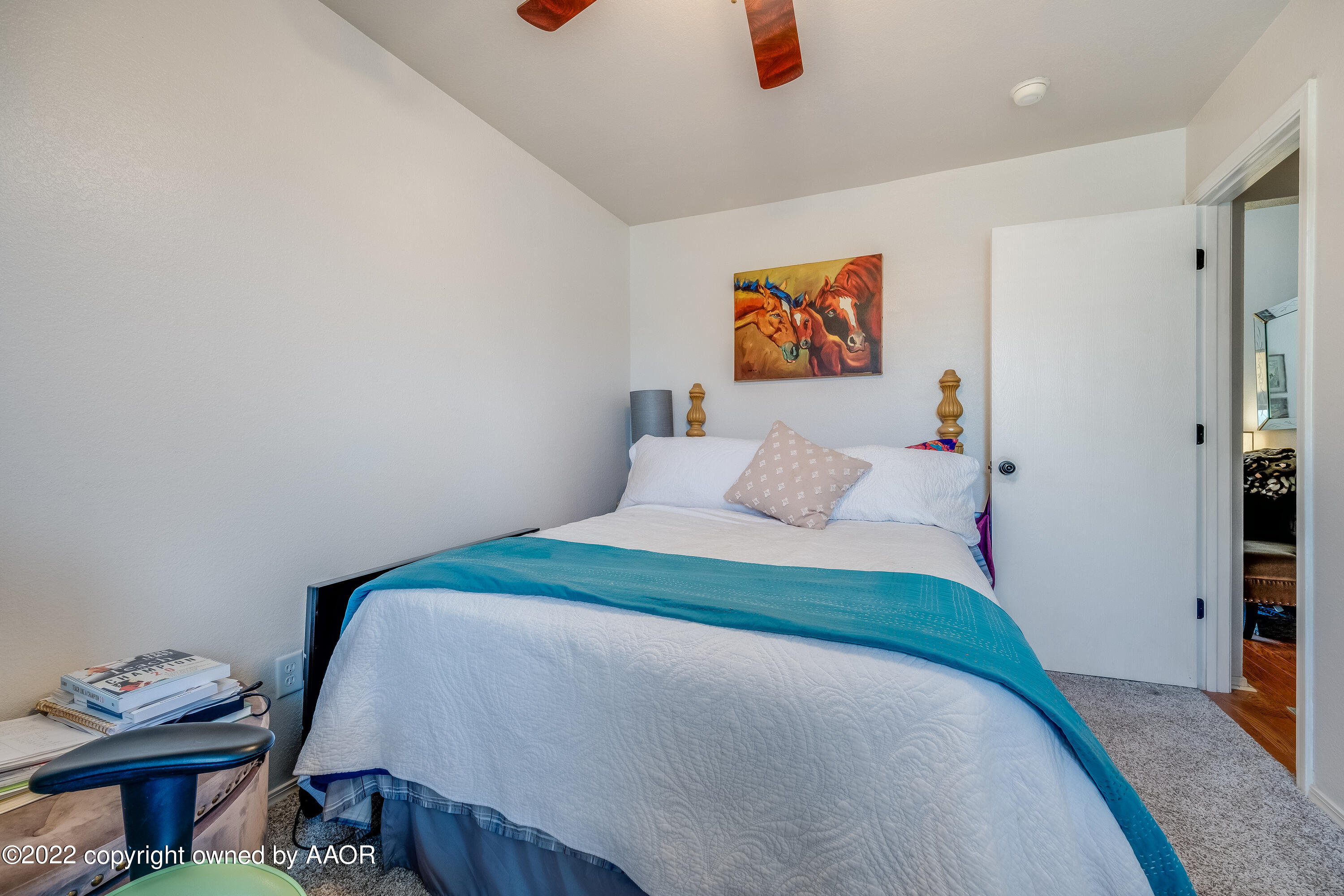 5001 Capulin Lane Amarillo, TX 79110 - Photo 20 of 22 a bedroom with a bed and wooden floor