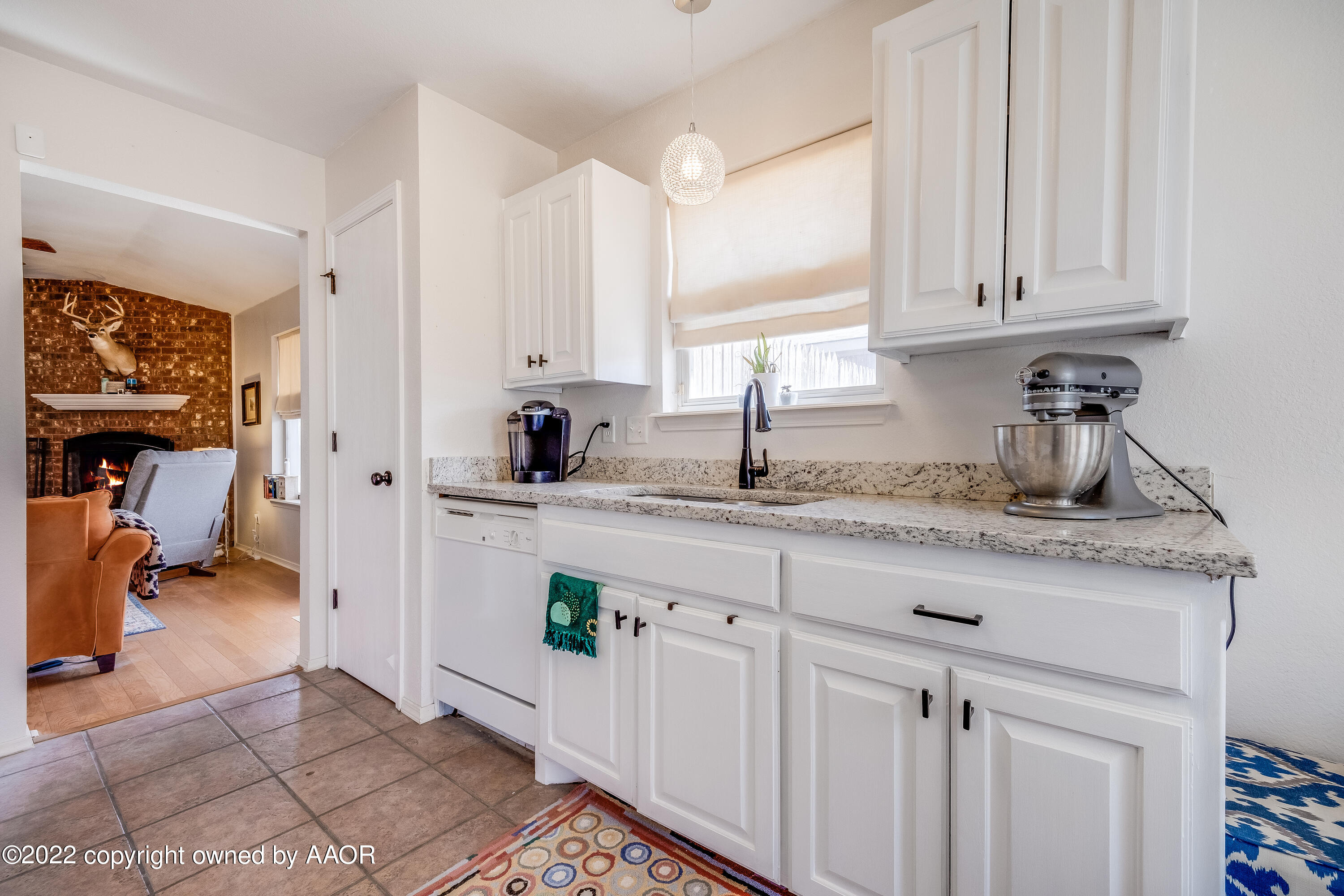 5001 Capulin Lane Amarillo, TX 79110 - Photo 5 of 22 a kitchen with granite countertop a sink stainless steel appliances white cabinets and a window