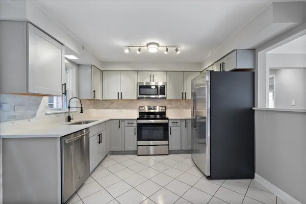 a kitchen with stainless steel appliances granite countertop a refrigerator and a sink