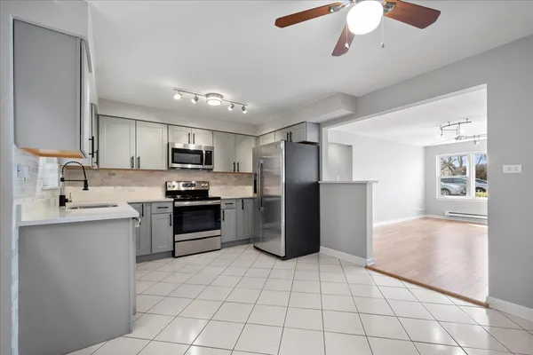 a kitchen with stainless steel appliances granite countertop a refrigerator and a stove top oven