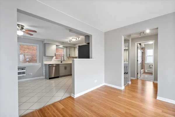 a large white kitchen with wooden floor and a sink