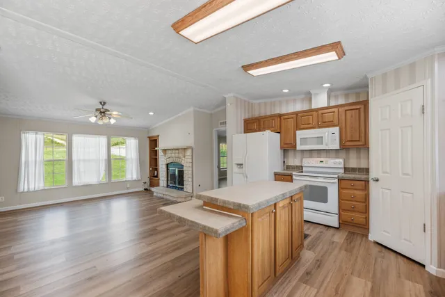 a kitchen with a refrigerator a stove top oven and wooden floor