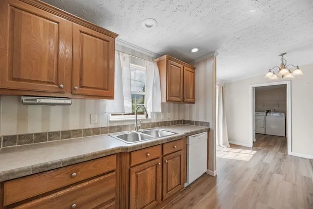 a kitchen with granite countertop a sink cabinets and wooden floor
