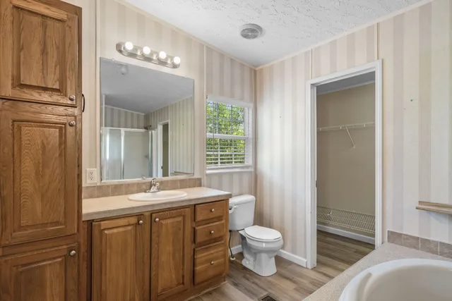 a bathroom with a granite countertop sink toilet and shower