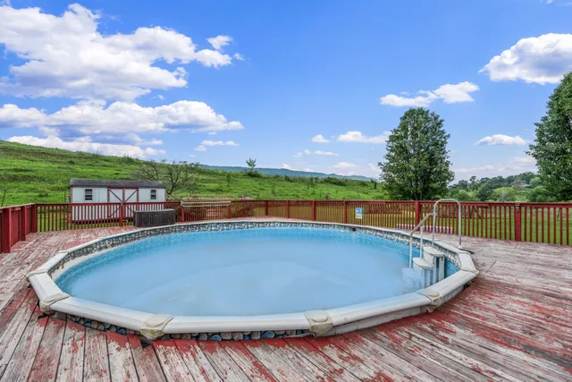 a view of a swimming pool with a yard and sitting area