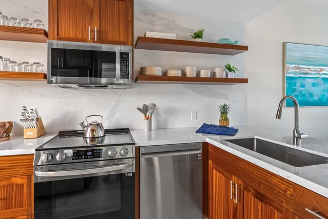 a kitchen with stainless steel appliances a sink a stove and a microwave