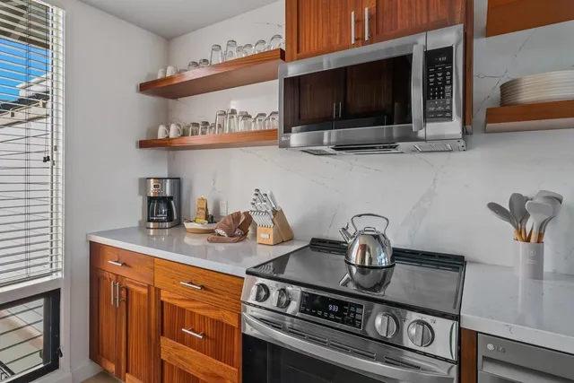 a kitchen with stainless steel appliances granite countertop a stove and a microwave