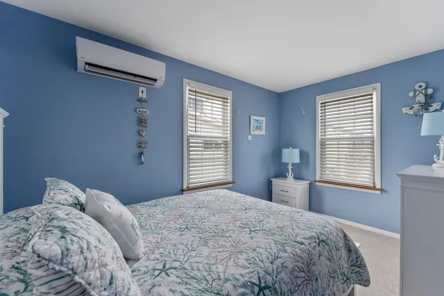 a bedroom with a bed and a window with chair