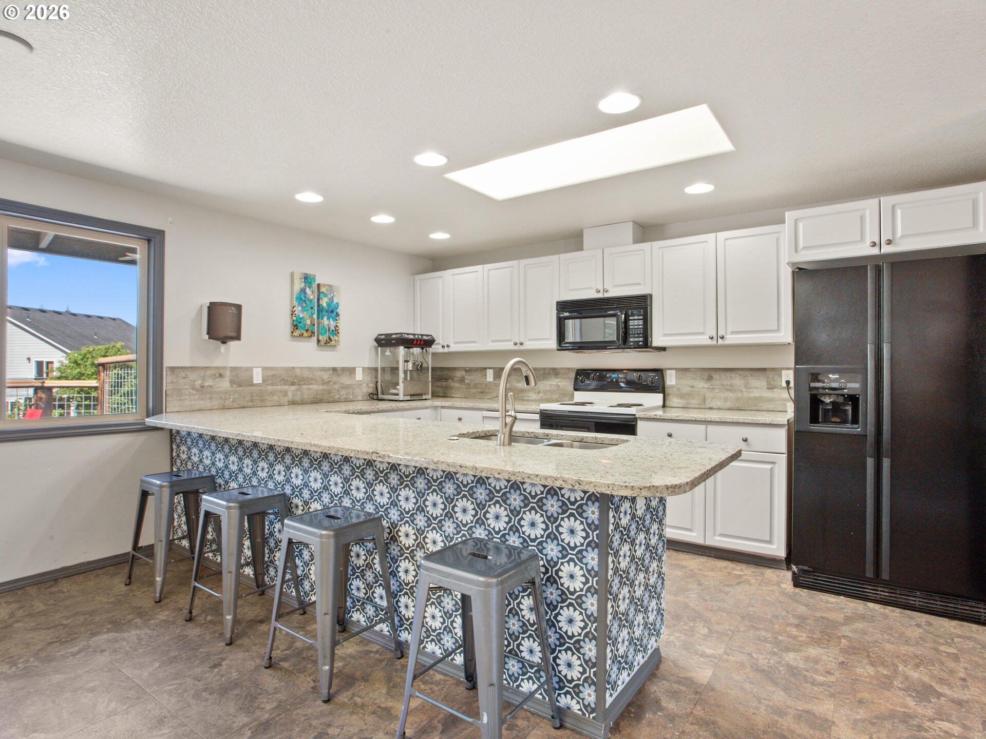 5468 J Street Washougal, WA 98671 - Photo 39 of 48 a kitchen with stainless steel appliances granite countertop a table chairs sink refrigerator and microwave