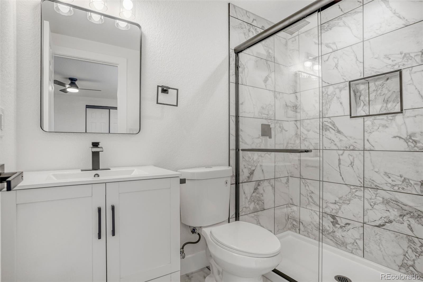 1057 Meade Street Denver, CO 80204 - Photo 21 of 38 a bathroom with a toilet sink and shower