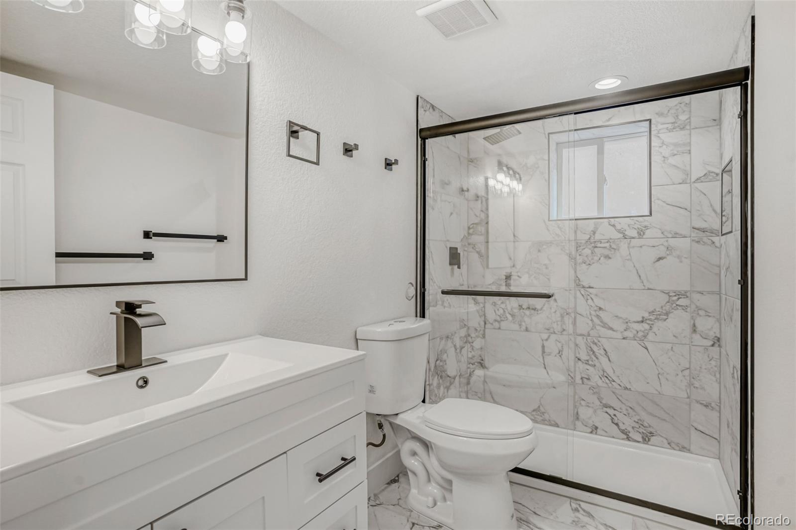 1057 Meade Street Denver, CO 80204 - Photo 23 of 38 a bathroom with a sink a toilet and shower
