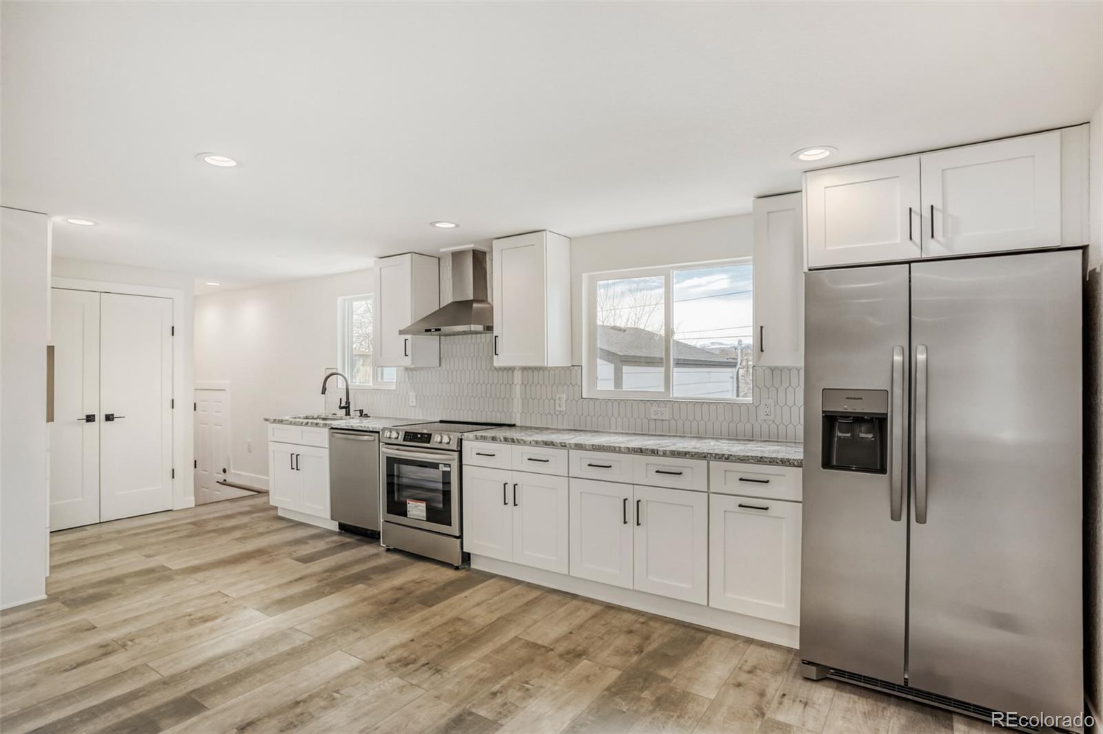 1057 Meade Street Denver, CO 80204 - Photo 7 of 38 a large kitchen with cabinets stainless steel appliances and a counter space