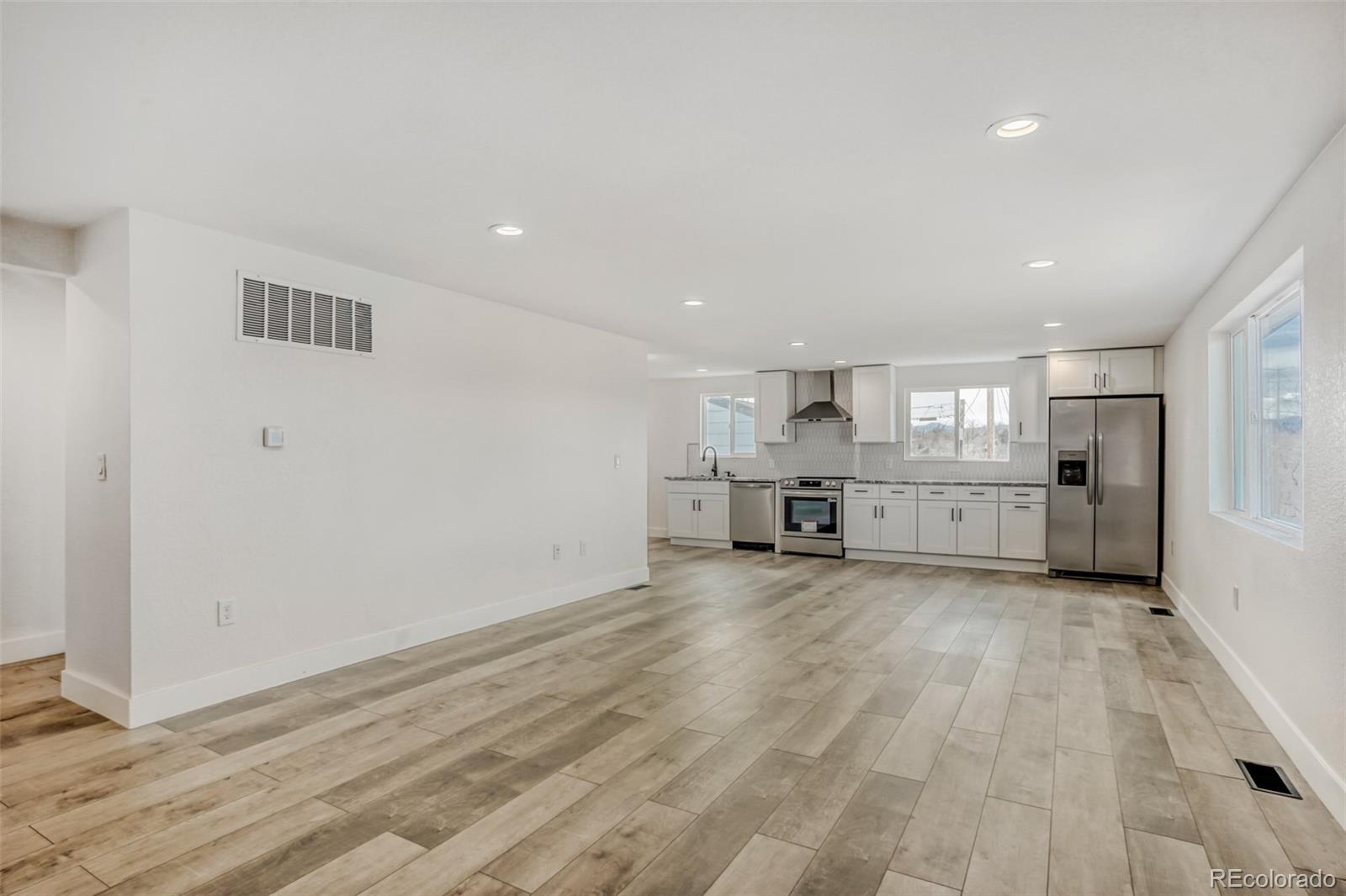 1057 Meade Street Denver, CO 80204 - Photo 8 of 38 an empty room with wooden floor and windows