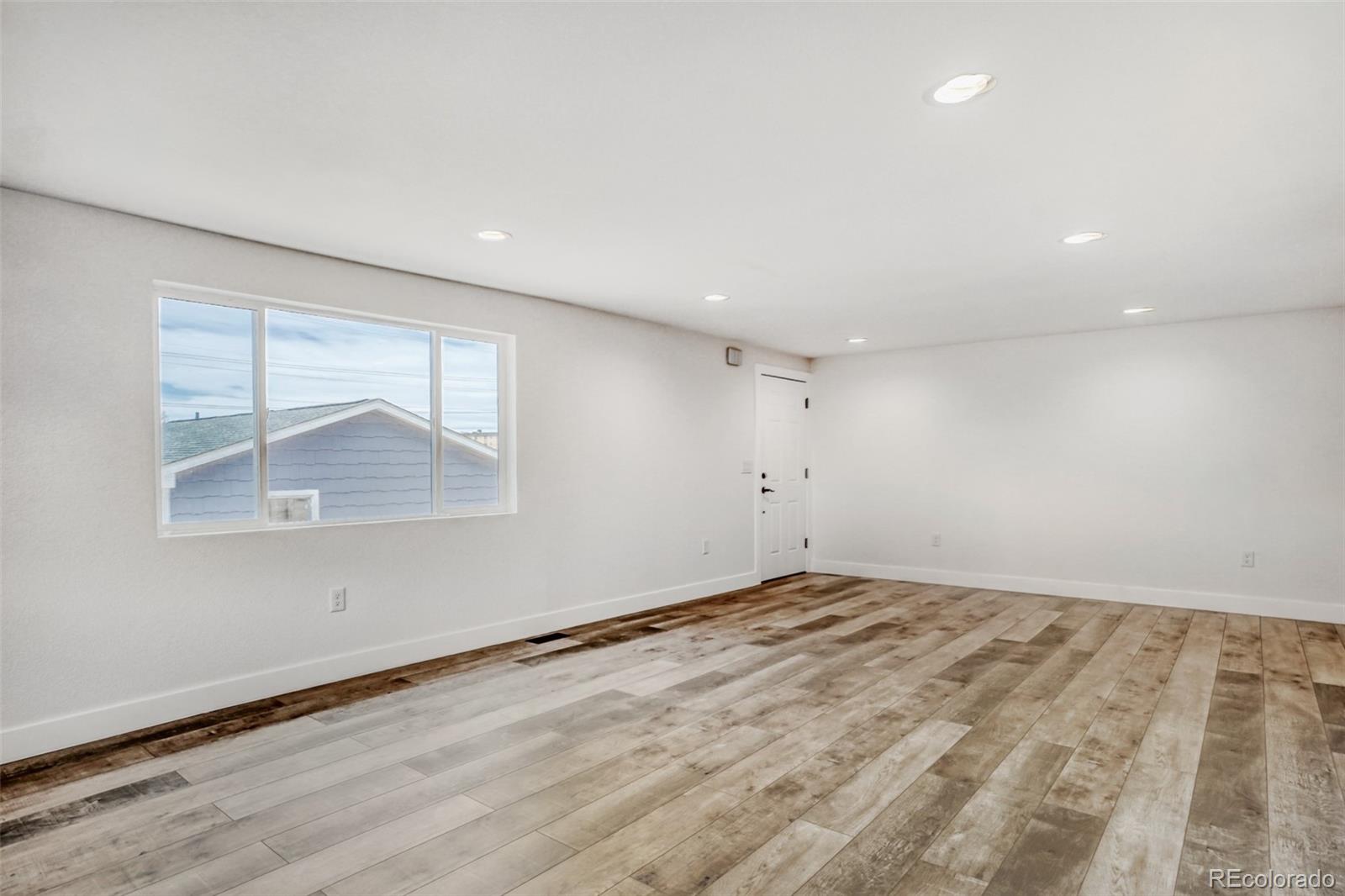 1057 Meade Street Denver, CO 80204 - Photo 9 of 38 an empty room with wooden floor and windows