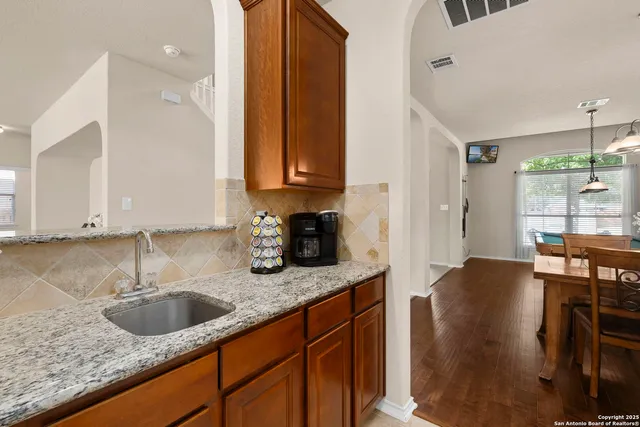 a kitchen with stainless steel appliances granite countertop a sink a stove and a refrigerator