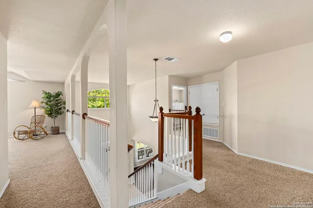 a view of a hallway to a livingroom with furniture