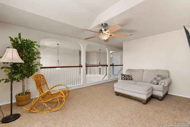 a living room with furniture ceiling fan and a potted plant