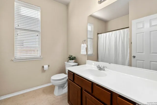 a bathroom with a sink a toilet and a large mirror
