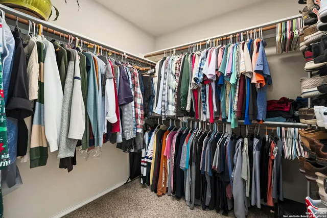 a view of walk in closet with clothes