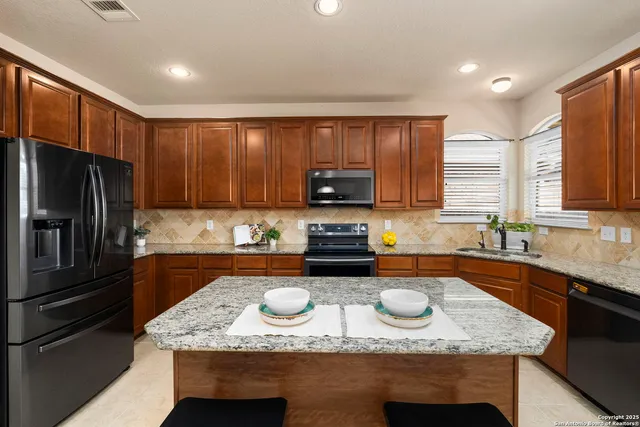 a kitchen with a sink a stove a refrigerator and cabinets