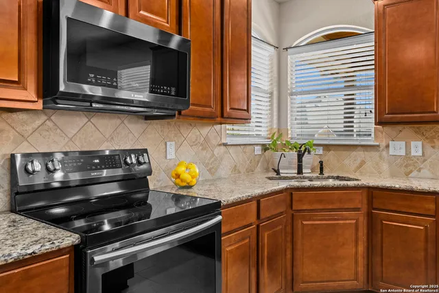 a kitchen with granite countertop a stove and a sink