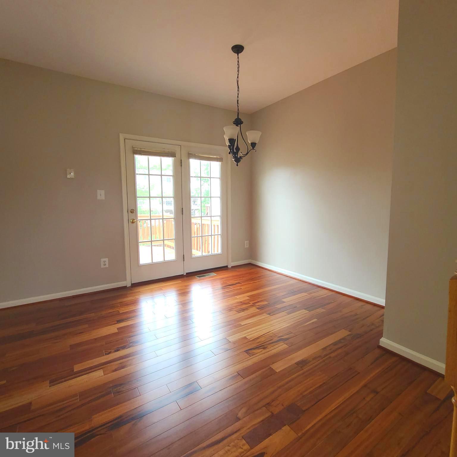 43393 Chokeberry Square Ashburn, VA 20147 - Photo 10 of 31 an empty room with wooden floor windows and ceiling fan