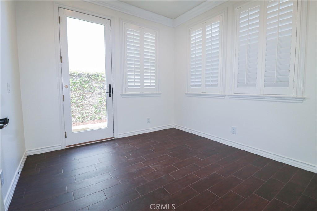 15205 Columbus Square Tustin, CA 92782 - Photo 8 of 43 an empty room with wooden floor and windows