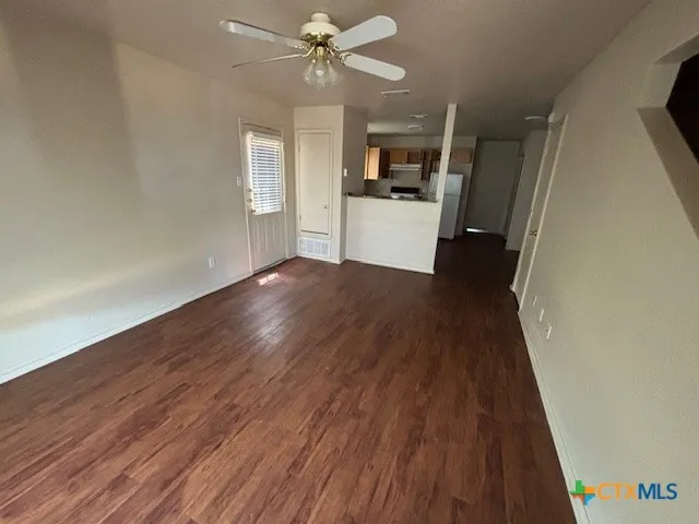 wooden floor in an empty room with a kitchen