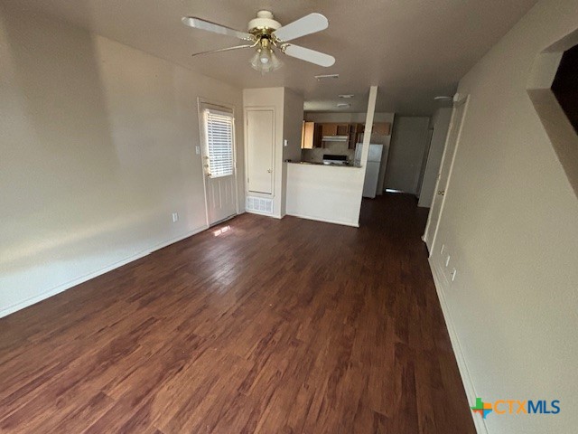 wooden floor in an empty room with a kitchen