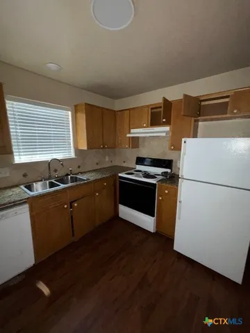 a kitchen with sink a microwave and refrigerator