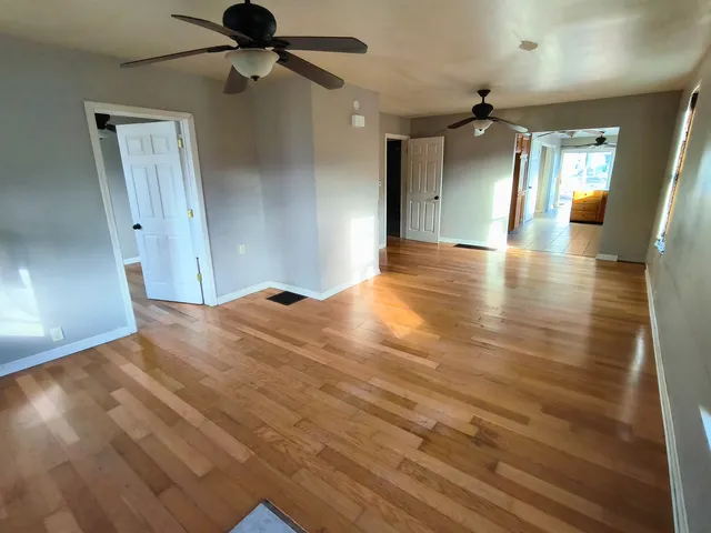 a view of empty room with wooden floor
