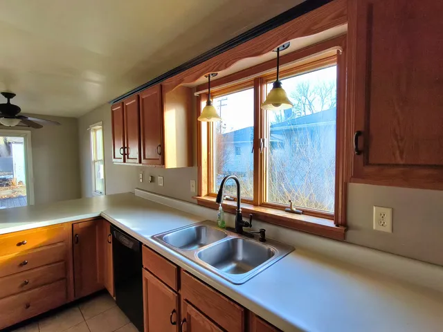 a kitchen with sink a window and cabinets