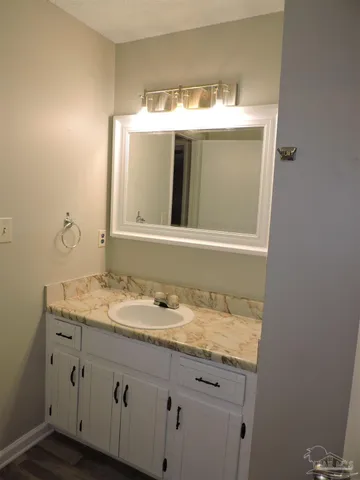 a bathroom with a granite countertop sink and a mirror