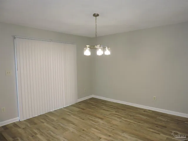 a view of a room with wooden floor and chandelier