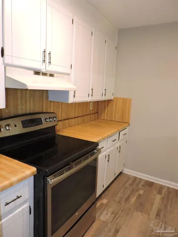 a kitchen with granite countertop a stove a sink and dishwasher