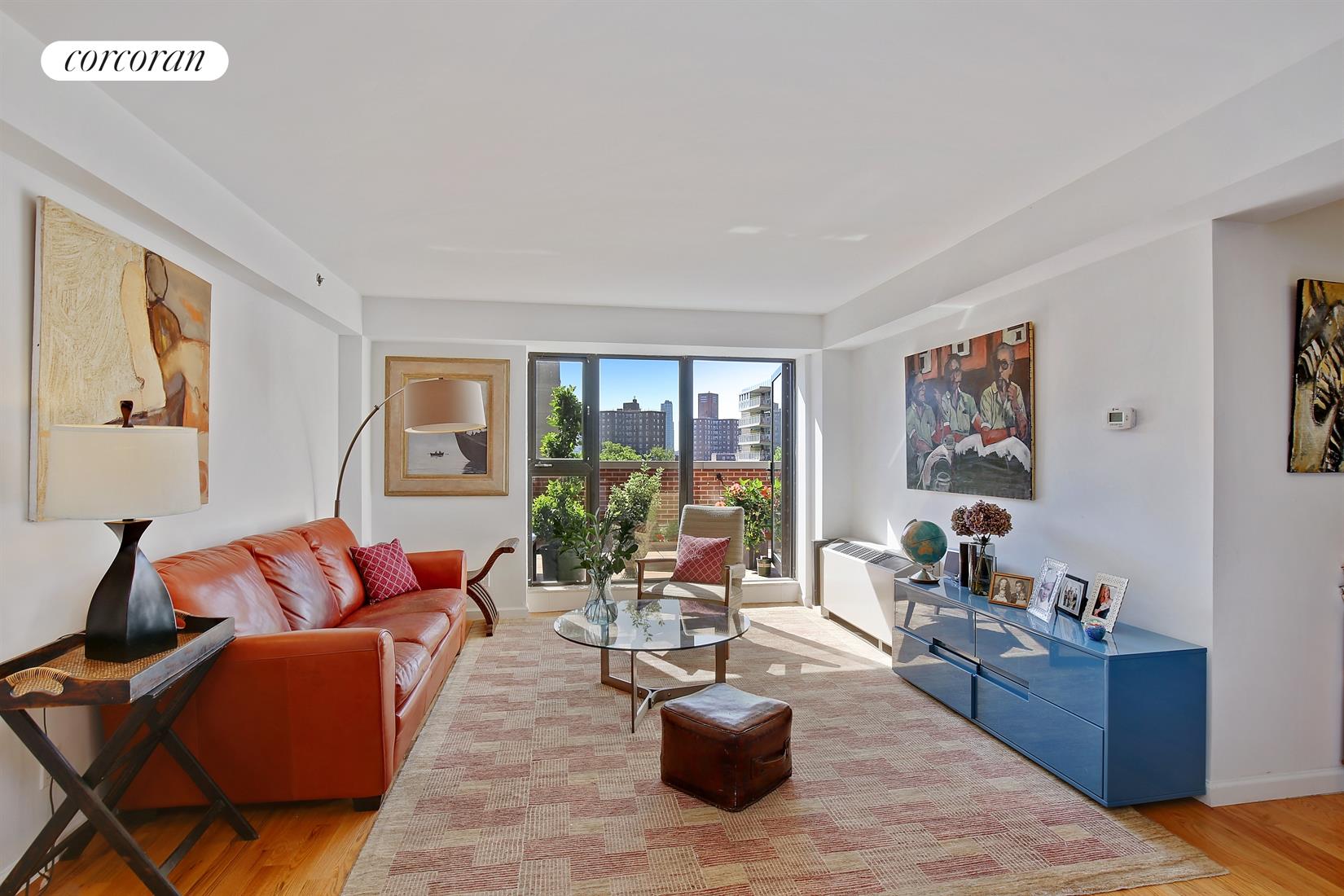189 Avenue C, Unit 7B Manhattan, NY 10009 - Photo 1 of 1 a living room with furniture potted plant and a large window